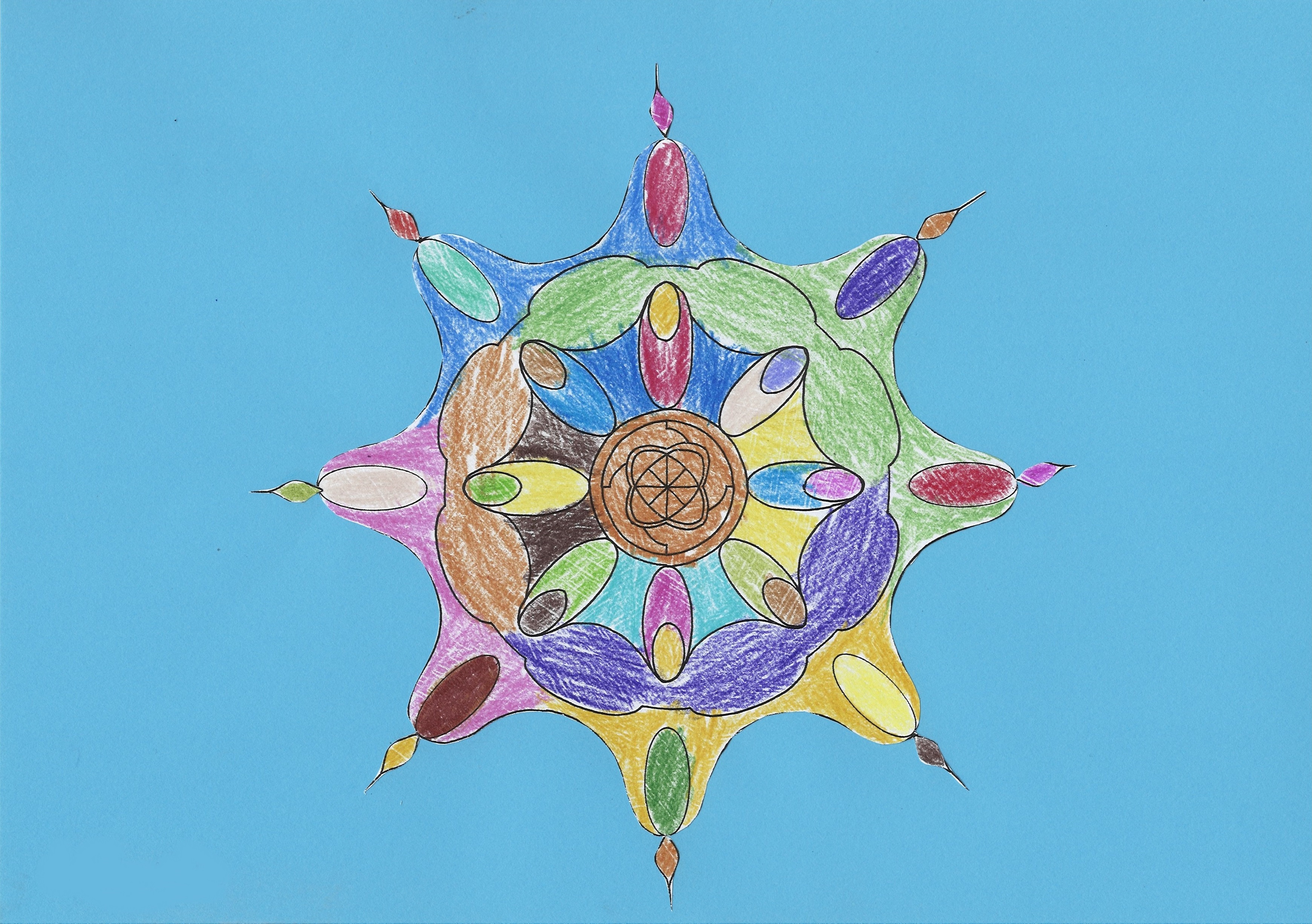 Obrazek wykonany techniką mieszaną przedstawiający różnobarwną mandalę z ośmioma ostro zakończonymi odnogami na niebieskim tle. 